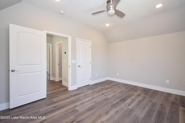 unfurnished bedroom featuring ceiling fan, dark hardwood / wood-style flooring, and lofted ceiling