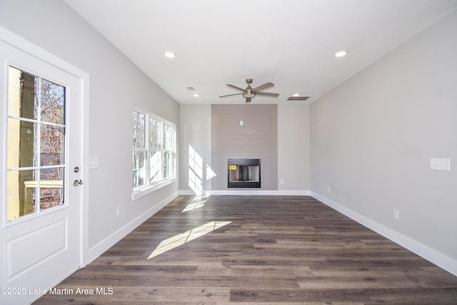 unfurnished living room with ceiling fan, dark hardwood / wood-style flooring, and a fireplace