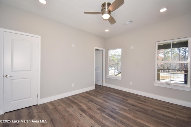 empty room with ceiling fan and dark wood-type flooring