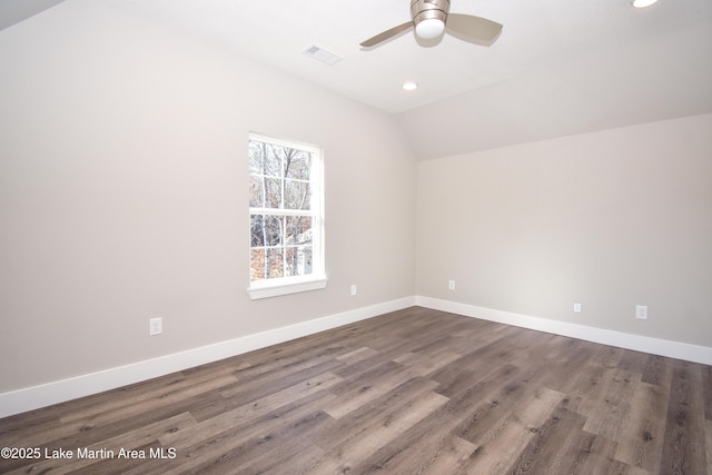 empty room with ceiling fan, wood-type flooring, and vaulted ceiling