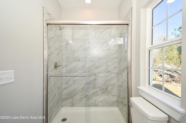 bathroom with a shower with door and a healthy amount of sunlight