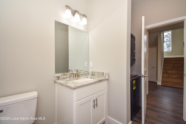 bathroom with wood-type flooring, vanity, and toilet