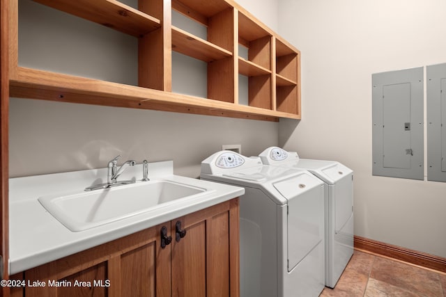 washroom featuring electric panel, separate washer and dryer, sink, and cabinets