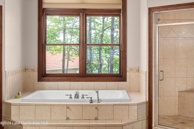 bathroom featuring separate shower and tub and plenty of natural light