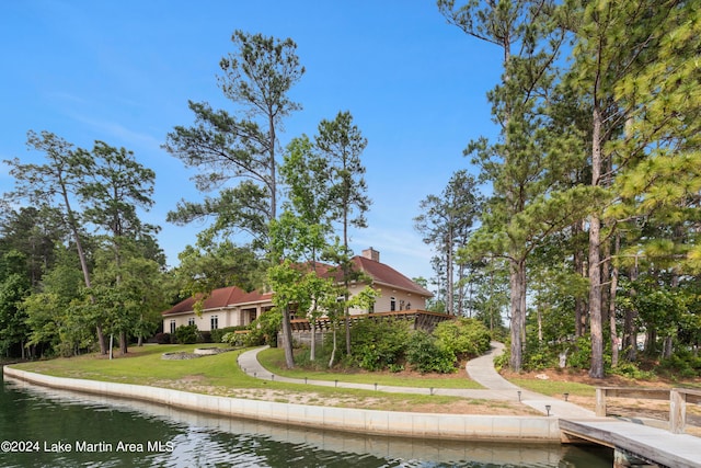 back of house featuring a yard and a water view