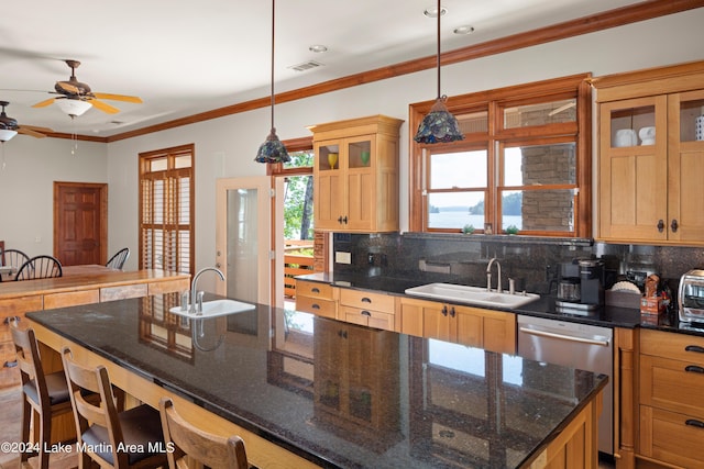 kitchen featuring decorative light fixtures, a kitchen breakfast bar, sink, and tasteful backsplash