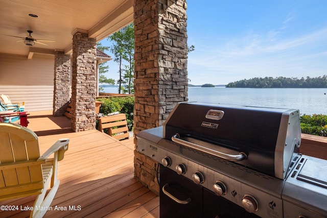 deck featuring ceiling fan, area for grilling, and a water view