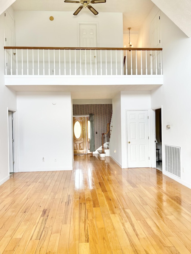 1370 County Road 759, Clanton, AL 35045 - unfurnished living room featuring a towering ceiling, a ceiling fan, light wood-style floors, and stairway