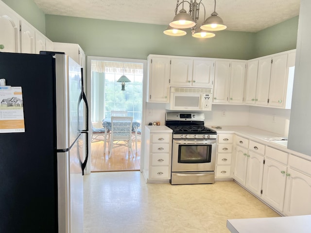 1370 County Road 759, Clanton, AL 35045 - kitchen with appliances with stainless steel finishes, white cabinets, light floors, light countertops, and a chandelier