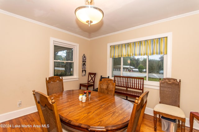 dining space with wood-type flooring and crown molding