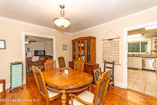 dining space with light wood-type flooring, ceiling fan, and ornamental molding