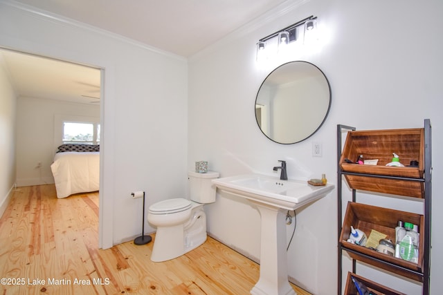 bathroom featuring hardwood / wood-style floors, toilet, and ornamental molding