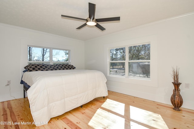 bedroom featuring ceiling fan, wood-type flooring, and ornamental molding