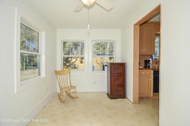 living area with ceiling fan and crown molding