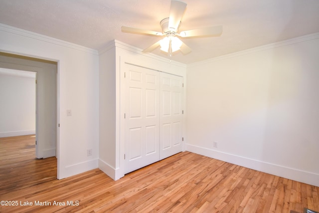 unfurnished bedroom featuring a closet, ceiling fan, light hardwood / wood-style flooring, and ornamental molding