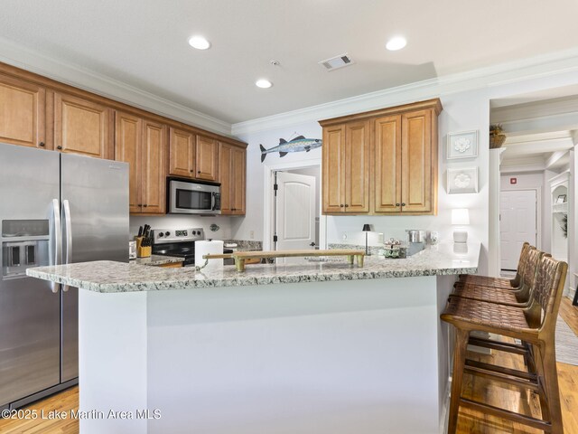 64 Stoneview Summit Ct Unit 5301, Dadeville, AL 36853 - kitchen with crown molding, visible vents, a kitchen breakfast bar, light stone counters, and appliances with stainless steel finishes