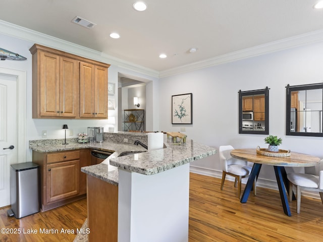 64 Stoneview Summit Ct Unit 5301, Dadeville, AL 36853 - kitchen featuring crown molding, light stone countertops, a peninsula, wood finished floors, and visible vents