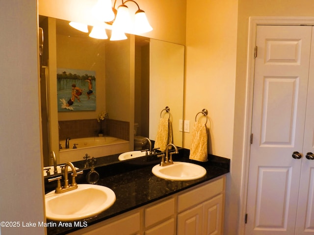 full bath with a sink, toilet, and double vanity