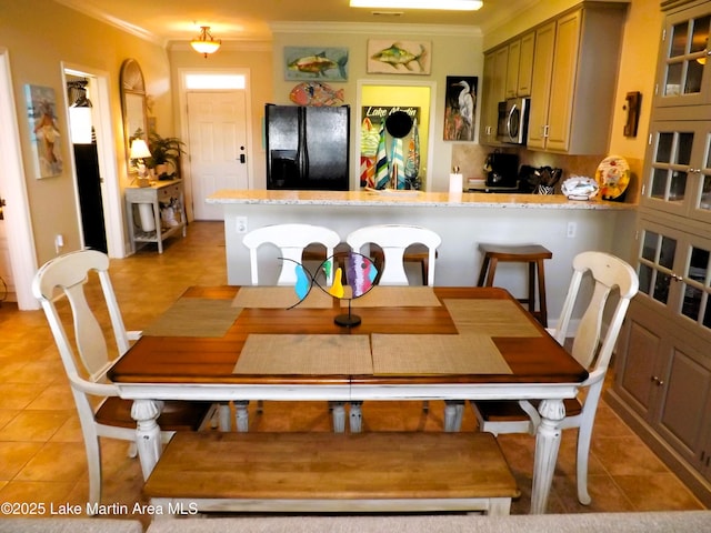 dining room with light tile patterned floors and ornamental molding