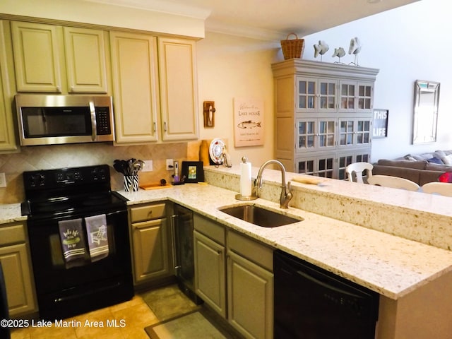 kitchen with light stone counters, a sink, black appliances, tasteful backsplash, and crown molding