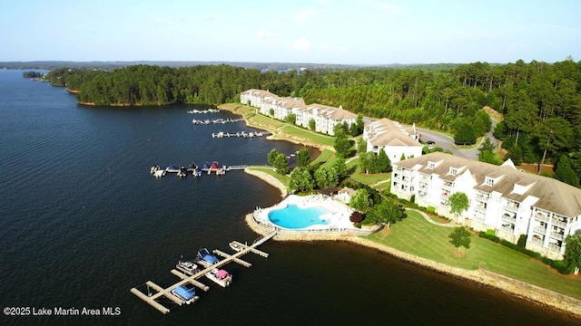 birds eye view of property with a water view and a wooded view