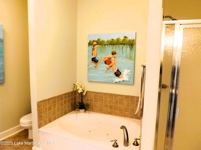 bathroom featuring toilet, a stall shower, and a garden tub