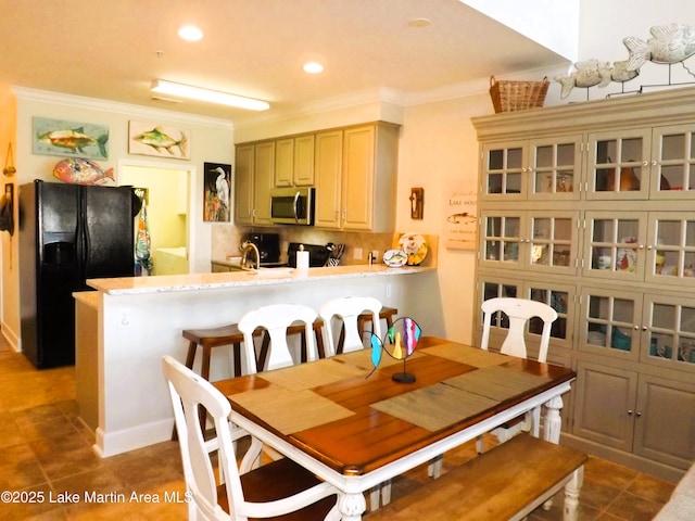 dining space with dark tile patterned floors, ornamental molding, and recessed lighting