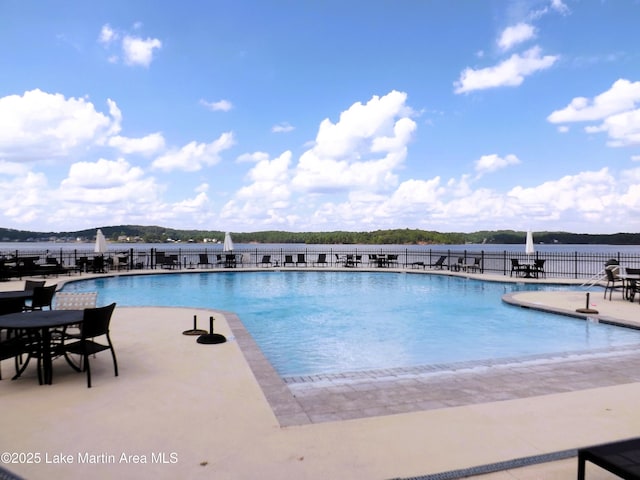 pool with a patio area and fence