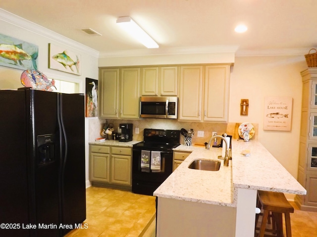 kitchen with ornamental molding, a sink, black appliances, a peninsula, and a kitchen breakfast bar