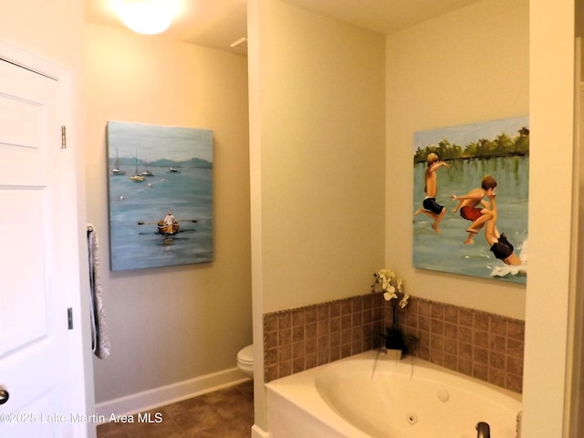 bathroom featuring a jetted tub, baseboards, toilet, and tile patterned flooring