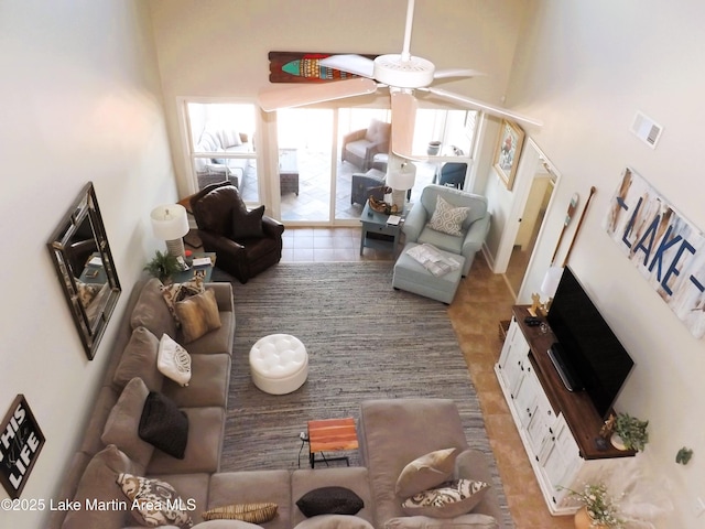 living area with a high ceiling, visible vents, and a ceiling fan