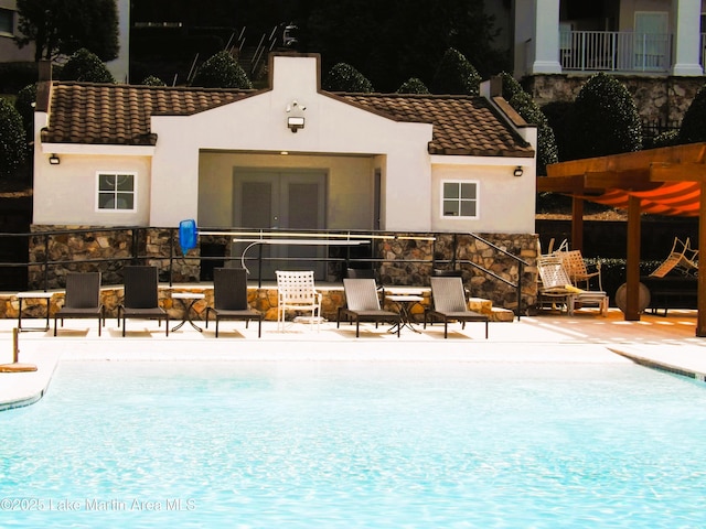 community pool with a patio area and a pergola