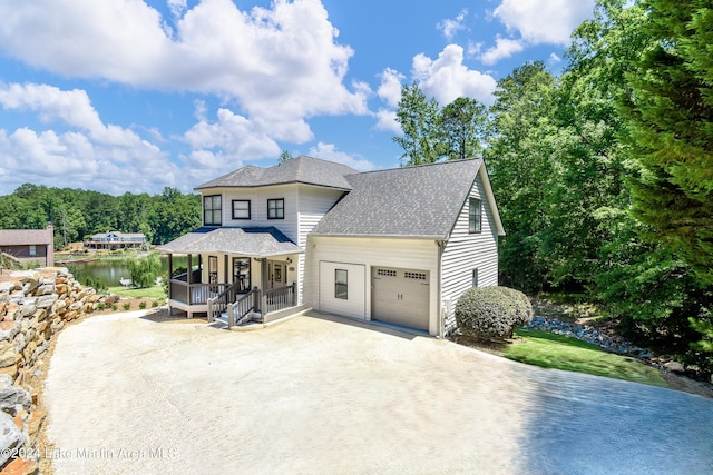 view of front of property with covered porch, dirt driveway, roof with shingles, and an attached garage