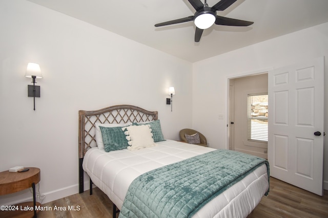 bedroom with ceiling fan, wood finished floors, and baseboards