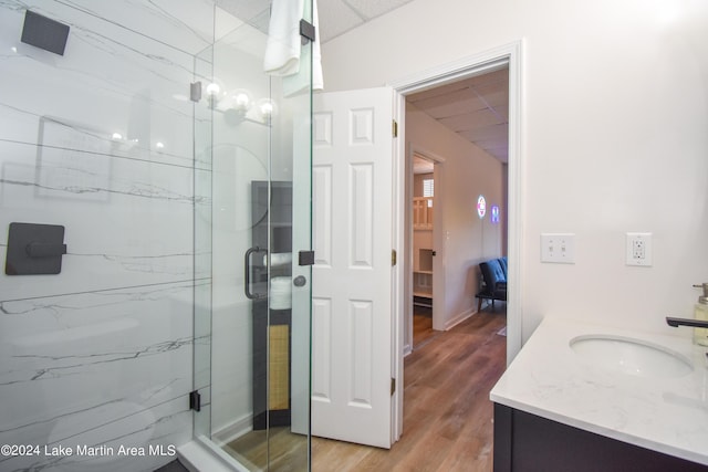 full bath featuring wood finished floors, a shower stall, and vanity