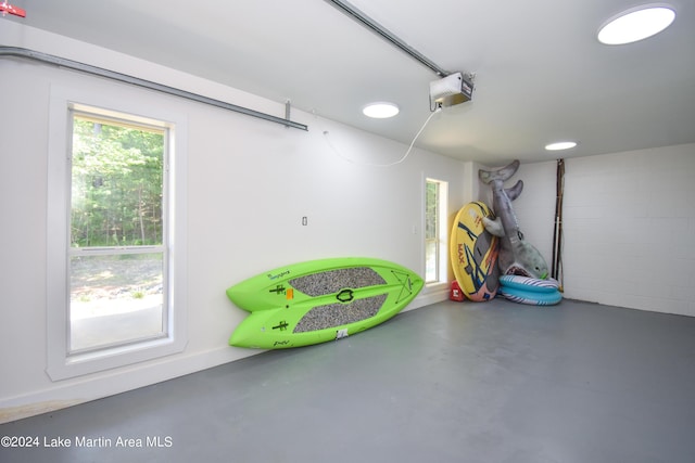 garage featuring concrete block wall and a garage door opener