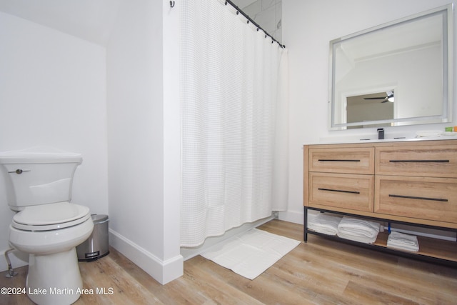 bathroom featuring toilet, wood finished floors, and a shower with shower curtain