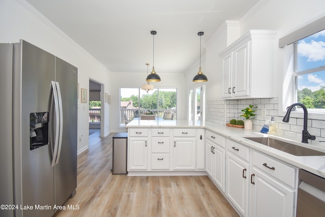 kitchen with tasteful backsplash, a peninsula, stainless steel appliances, crown molding, and a sink