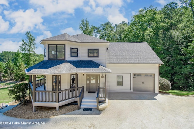 view of front of house with an attached garage, driveway, a porch, and roof with shingles