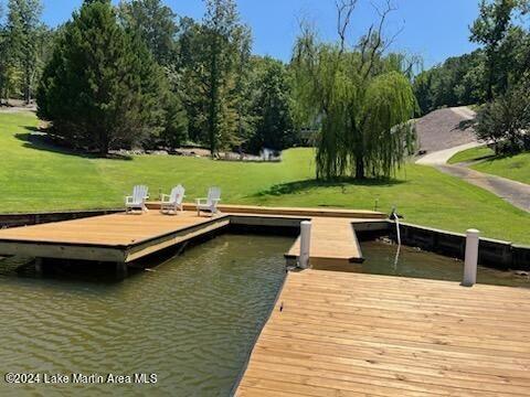 dock area with a water view and a yard