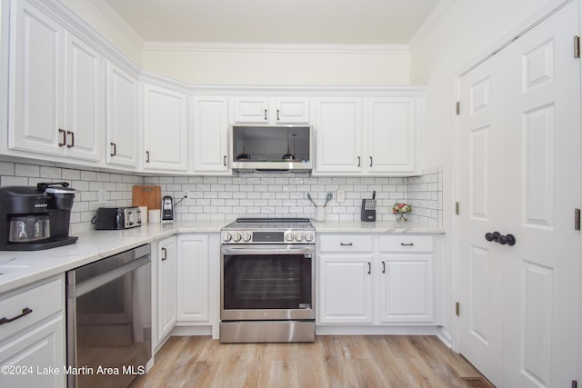 kitchen with white cabinetry, appliances with stainless steel finishes, light wood-type flooring, backsplash, and crown molding