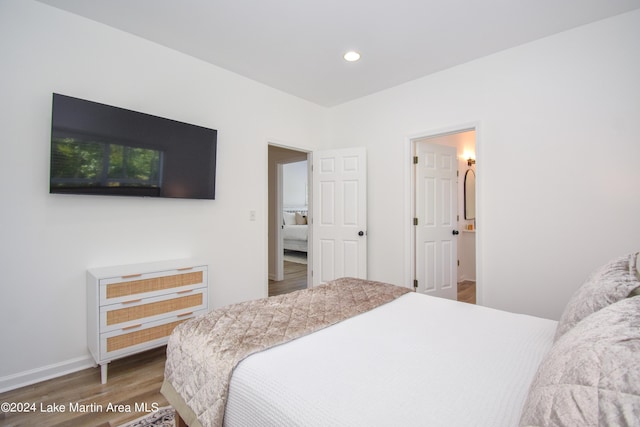 bedroom with recessed lighting, wood finished floors, and baseboards