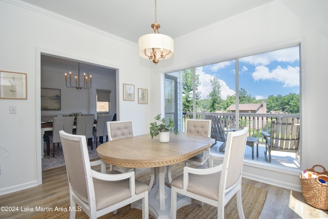 dining room with baseboards, crown molding, an inviting chandelier, and wood finished floors