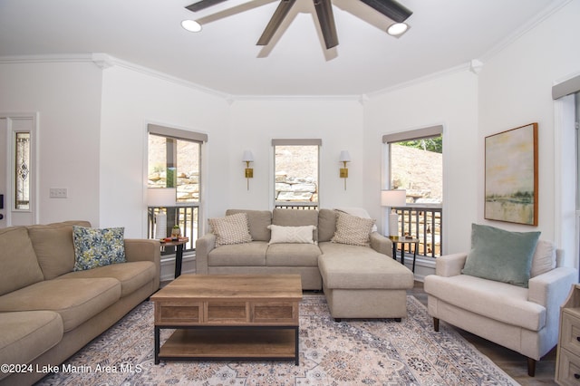 living area featuring a healthy amount of sunlight, ceiling fan, ornamental molding, and wood finished floors