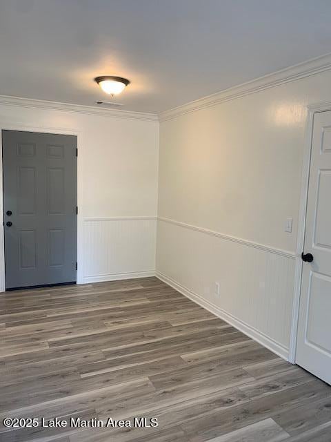 spare room featuring ornamental molding and hardwood / wood-style flooring