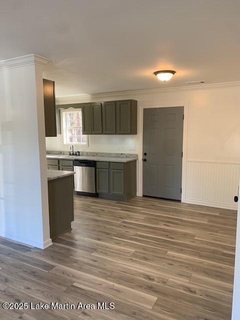 kitchen with ornamental molding, stainless steel dishwasher, and dark hardwood / wood-style floors