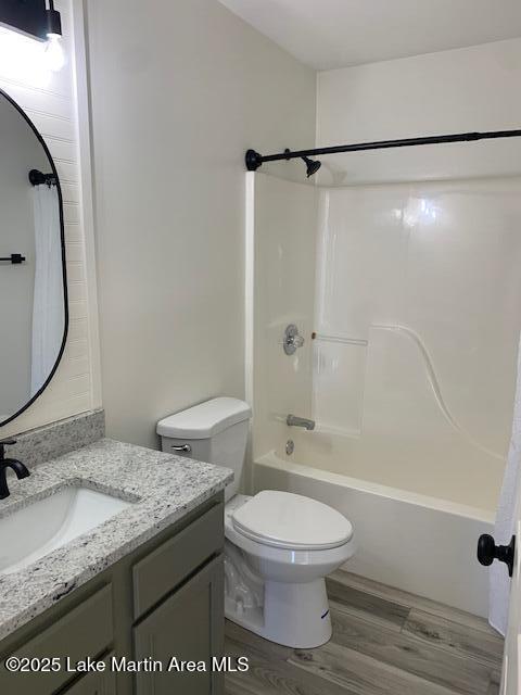 full bathroom with toilet, wood-type flooring, vanity, and shower / bathing tub combination