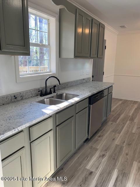 kitchen featuring light stone countertops, crown molding, dishwasher, and sink