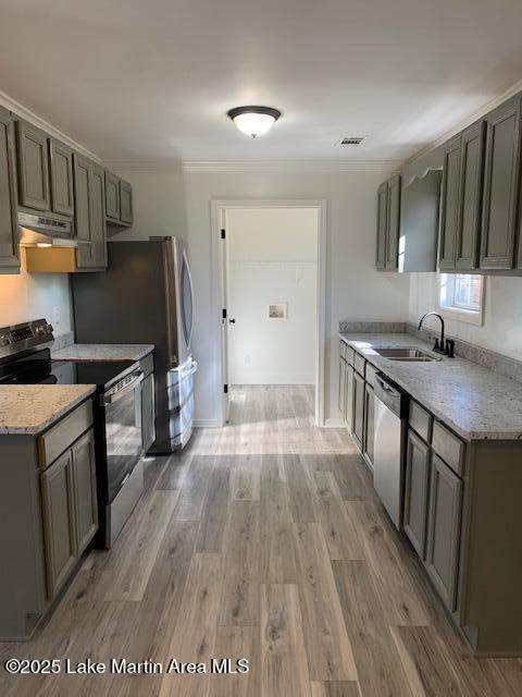 kitchen featuring sink, ornamental molding, stainless steel appliances, and light hardwood / wood-style flooring