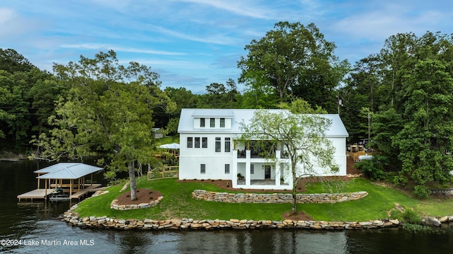 rear view of house featuring a water view, a yard, and a balcony